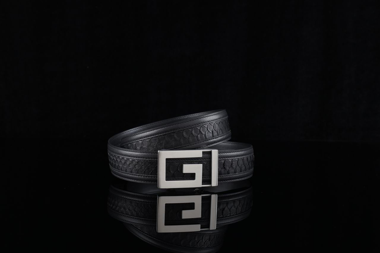 Elegant black leather belt with unique buckle design against a dark background.